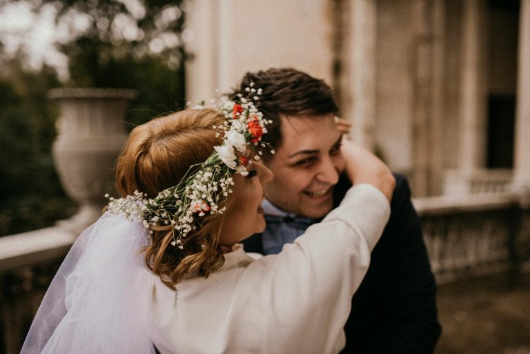 Braut mit Blumenkranz umarmt Bräutigam